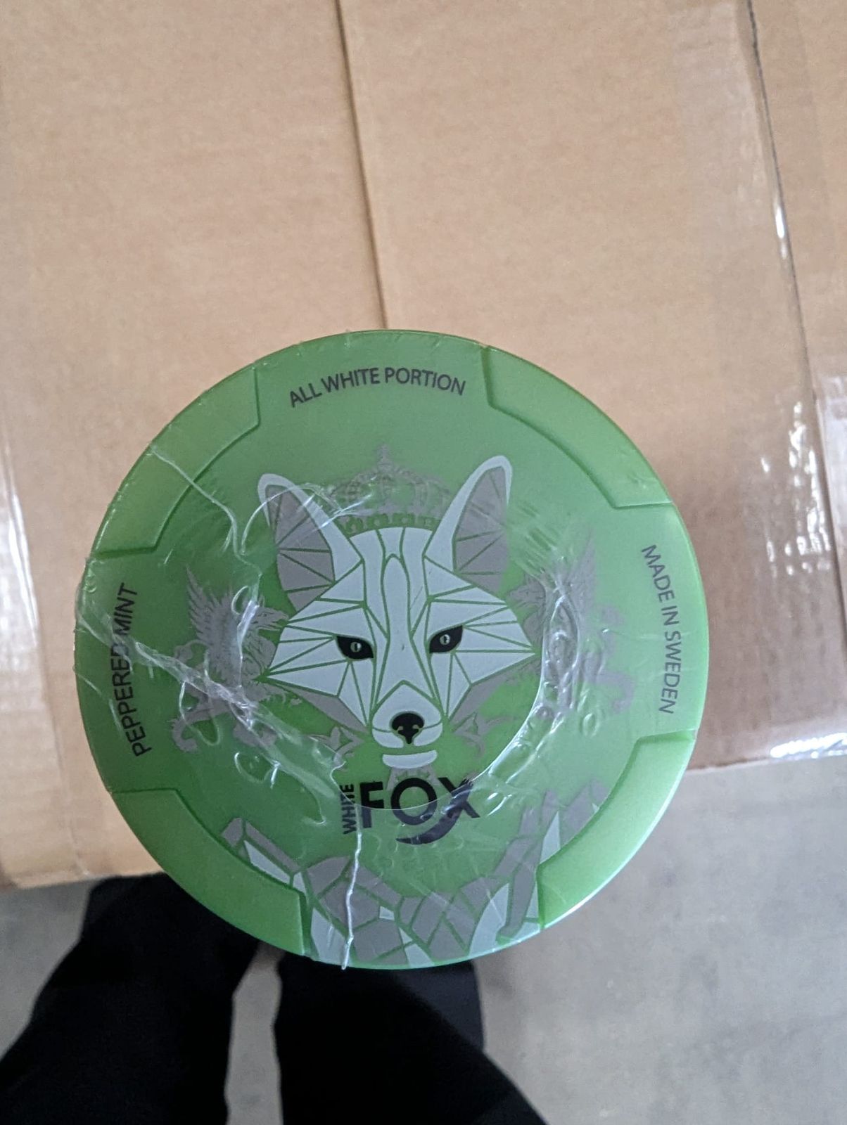 White Fox Peppered Mint nicotine pouches can top view on cardboard